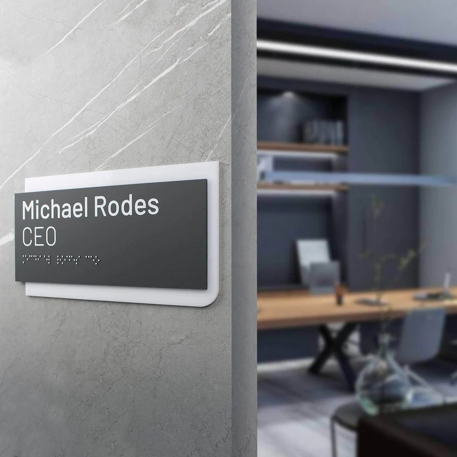 Офісна табличка із шрифтом Брайля на стіні